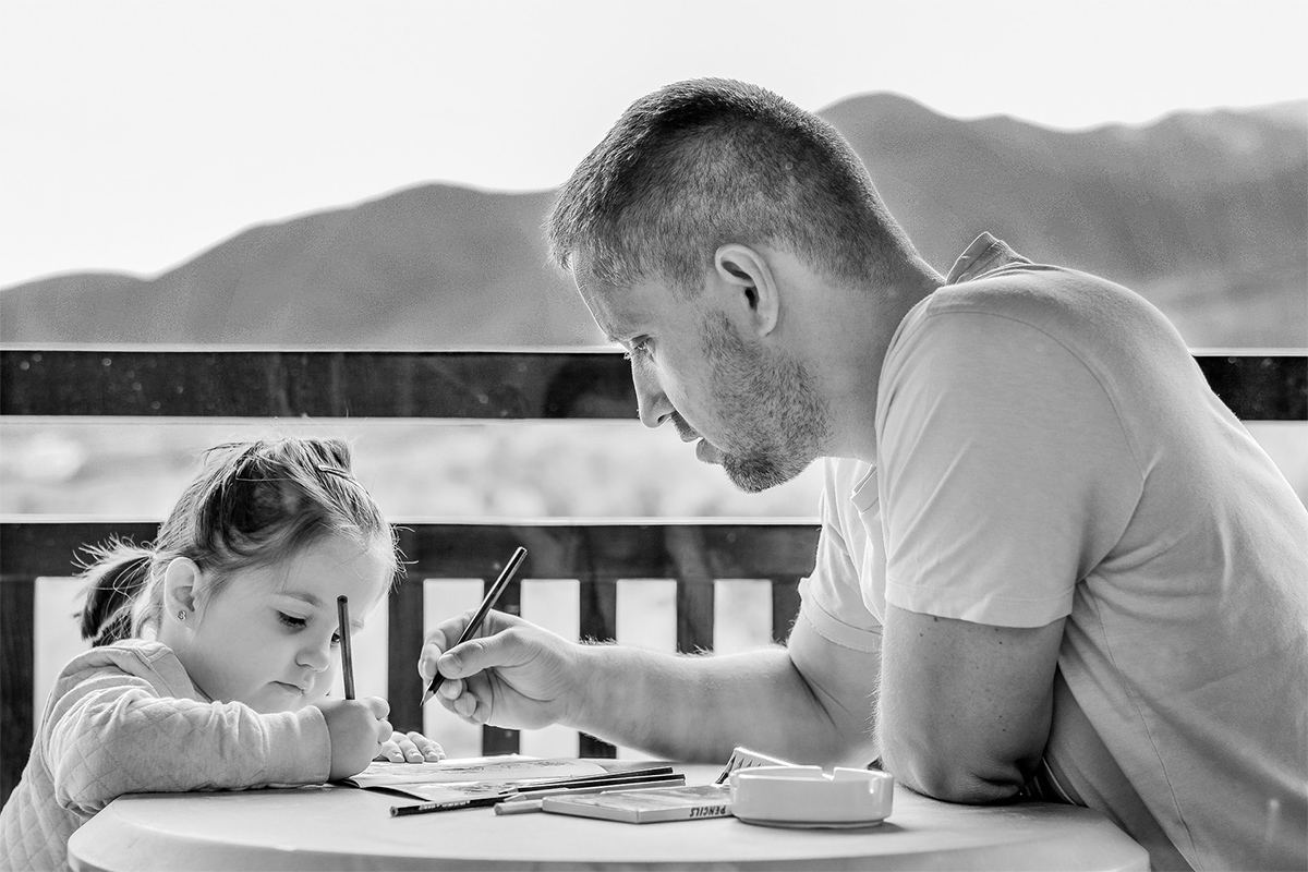 a father teaching her daughter to write. Dad is doing learning evaluation