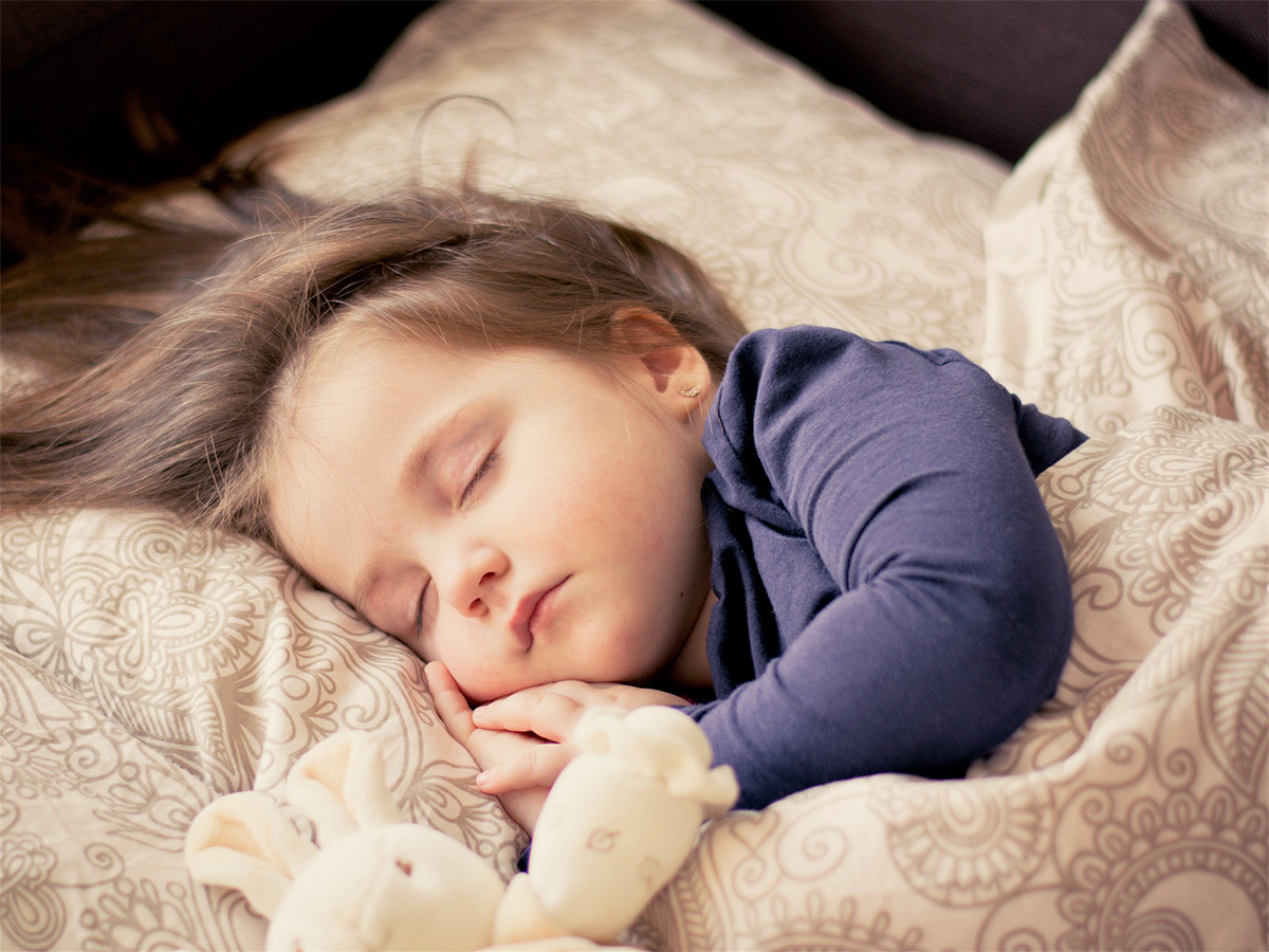 a young girl sleeping soundly. she has a healthy sleep practice